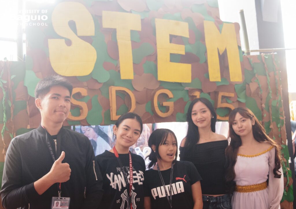 University of Baguio High School (UBHS) students proudly showcase their creative and educational booth during the High School Day 2025 celebration, highlighting innovation, teamwork, and environmental awareness.