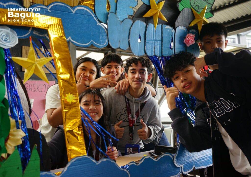 University of Baguio High School (UBHS) students proudly showcase their creative and educational booth during the High School Day 2025 celebration, highlighting innovation, teamwork, and environmental awareness.