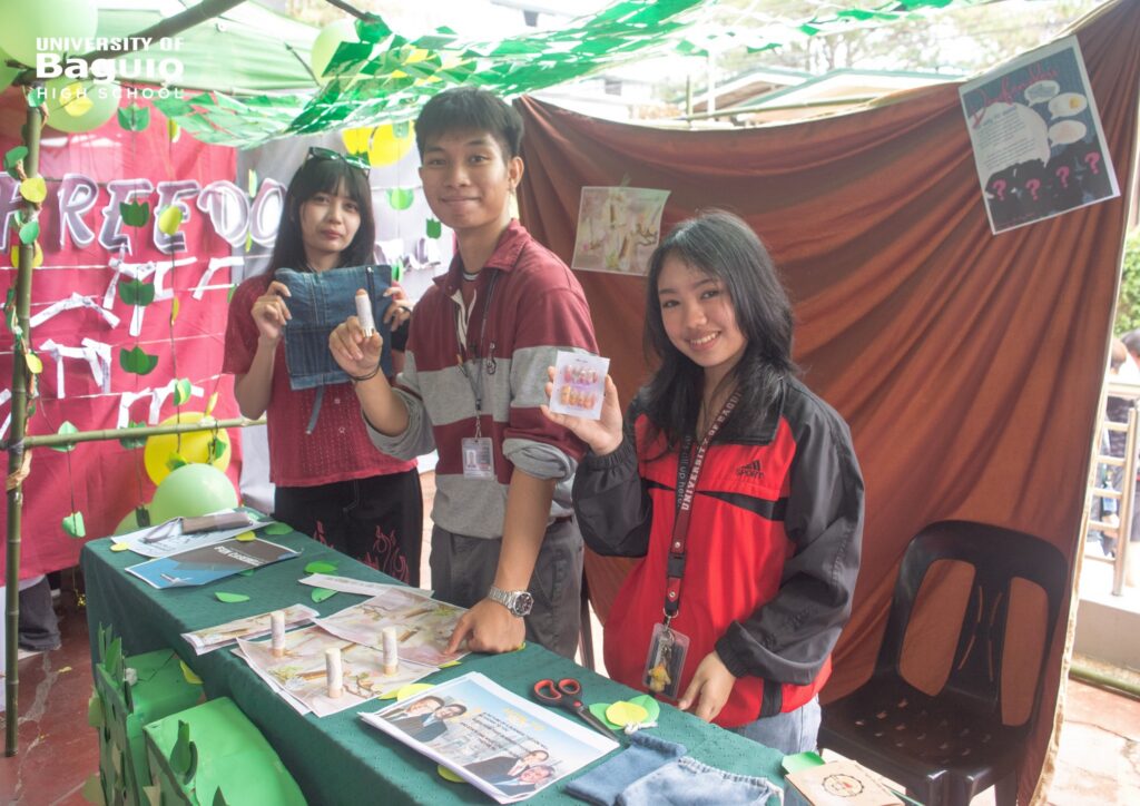 University of Baguio High School (UBHS) students proudly showcase their creative and educational booth during the High School Day 2025 celebration, highlighting innovation, teamwork, and environmental awareness.