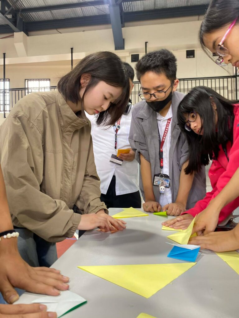 Japanese exchange student teaches UBHS students how to fold origami during the GAWIS 3 Philippines–Japan cultural exchange.